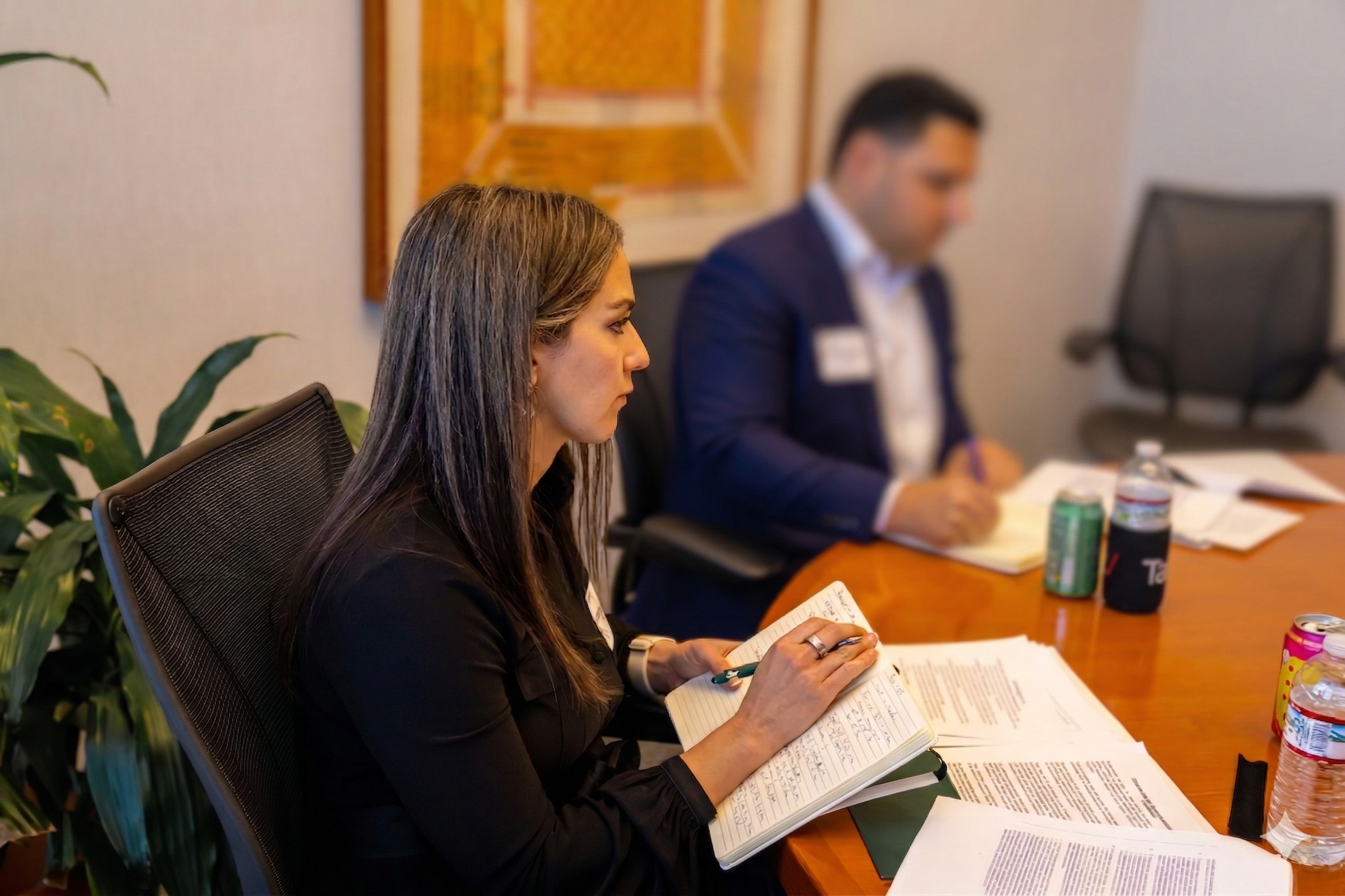 Vanessa Bailey taking notes across marked-up documents in a boardroom